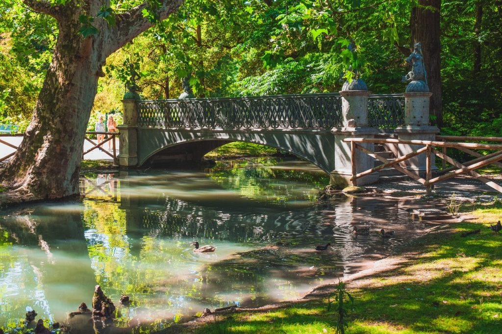 pont historique sur un canal avec arbres et parc verdoyant en italie