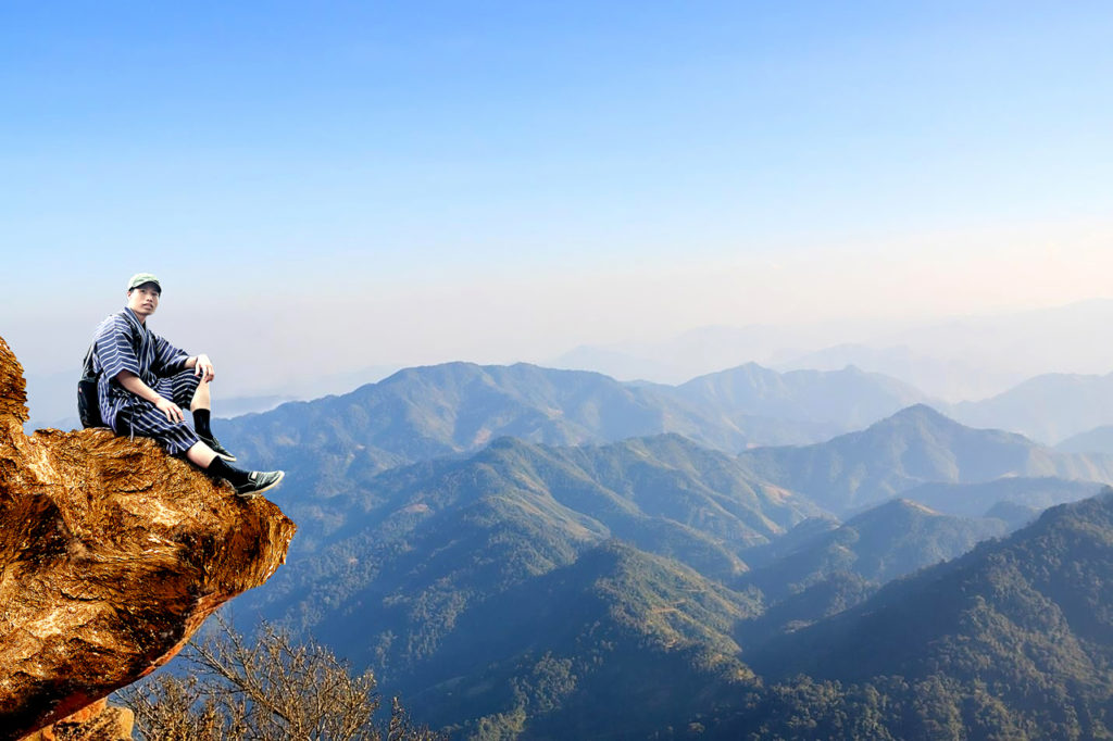 voyageur admirant les montagnes depuis une falaise rocheuse