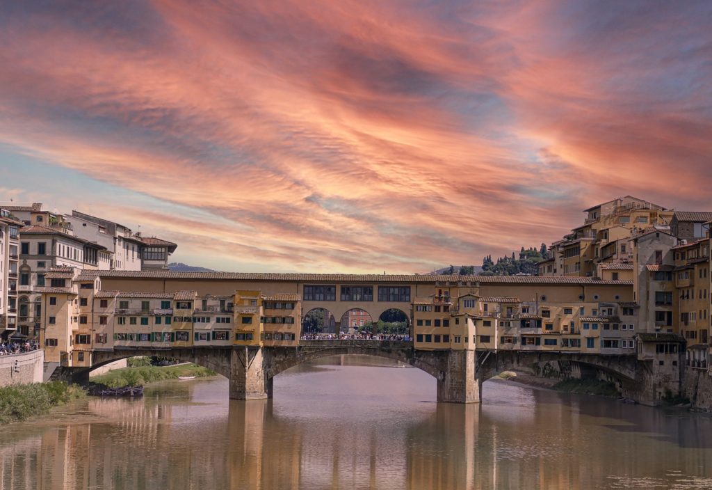 le ponte vecchio enjambant l'arno à florence sous un coucher de soleil rose