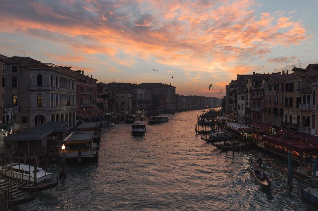 canal grande de venise au coucher de soleil avec gondoles et bâtiments historiques