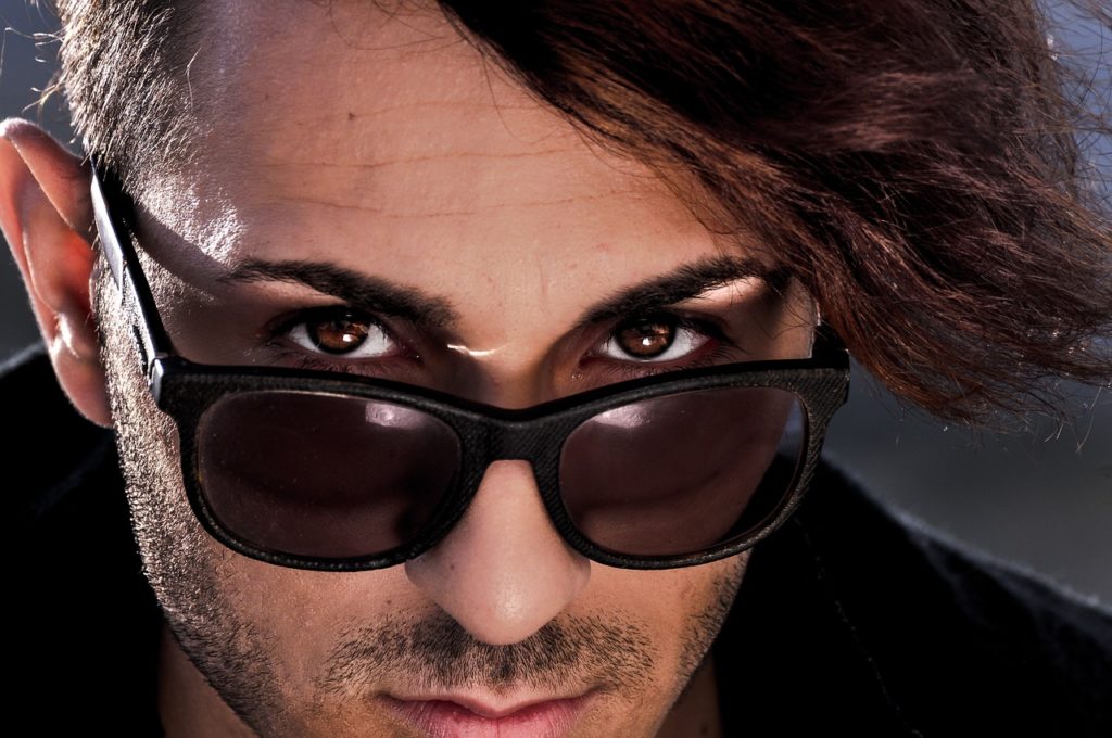 homme italien avec lunettes de soleil noires et barbe, regard intense