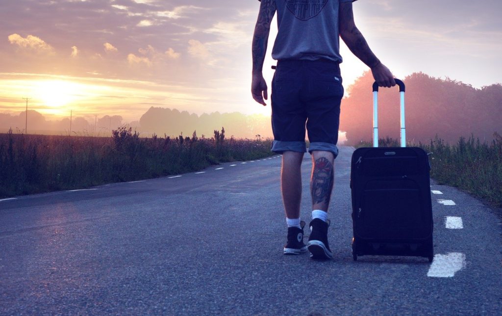 voyageur avec valise sur route au coucher de soleil en italie du nord