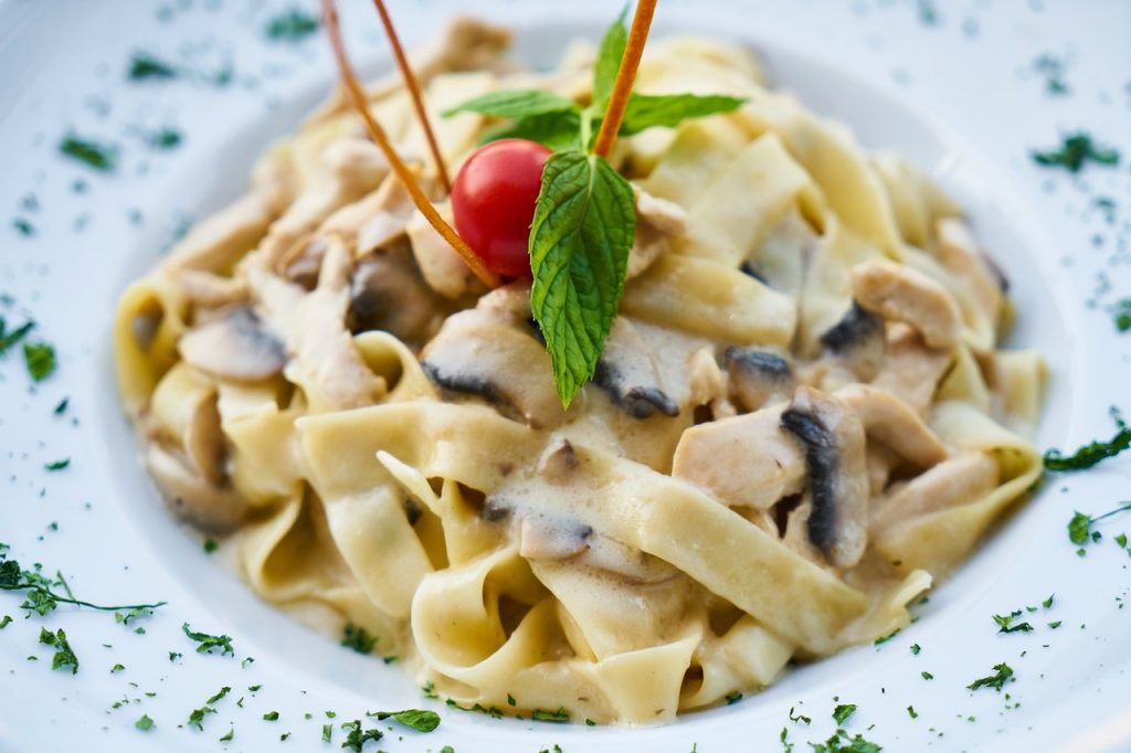 pâtes aux champignons sauce crème, décorées de menthe et tomate cerise
