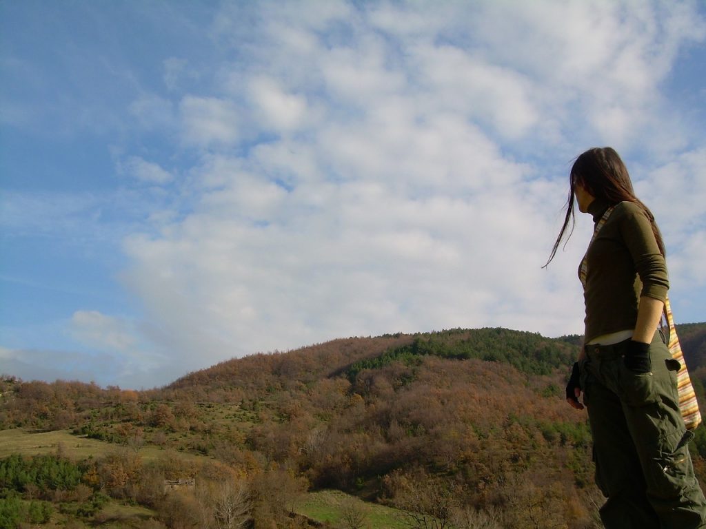 femme contemplant les montagnes automnales d'Italie sous un ciel nuageux
