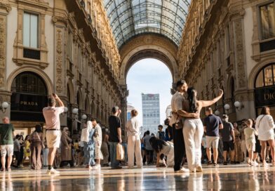 Comment s’habiller en Italie homme : guide par saison Couple taking a selfie in a grand european arcade