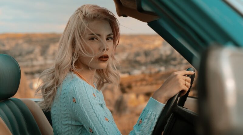 Road trip Toscane sans voiture : quoi porter sur 4 jours woman in blue button up long sleeve shirt holding car steering wheel during daytime