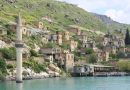 Picturesque Halfeti village with stone houses along the river, surrounded by lush hills.
