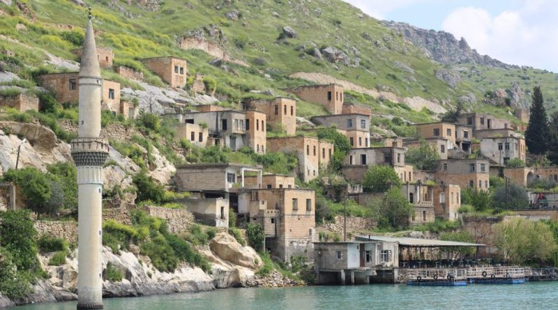 Picturesque Halfeti village with stone houses along the river, surrounded by lush hills.