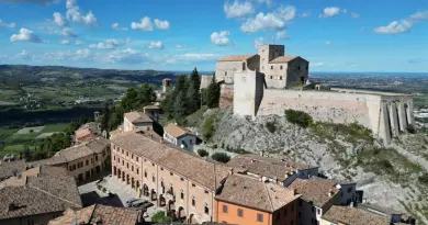 A stunning aerial view of the historic Verucchio Castle in Emilia-Romagna, Italy, against a clear sky.