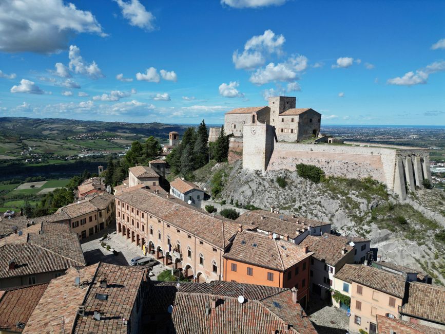 A stunning aerial view of the historic Verucchio Castle in Emilia-Romagna, Italy, against a clear sky.