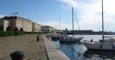 Itinéraire Frioul-Vénétie Julienne 6 jours : Trieste, Aquilée Explore the picturesque waterfront in Trieste, Italy with docked sailboats and historic architecture.