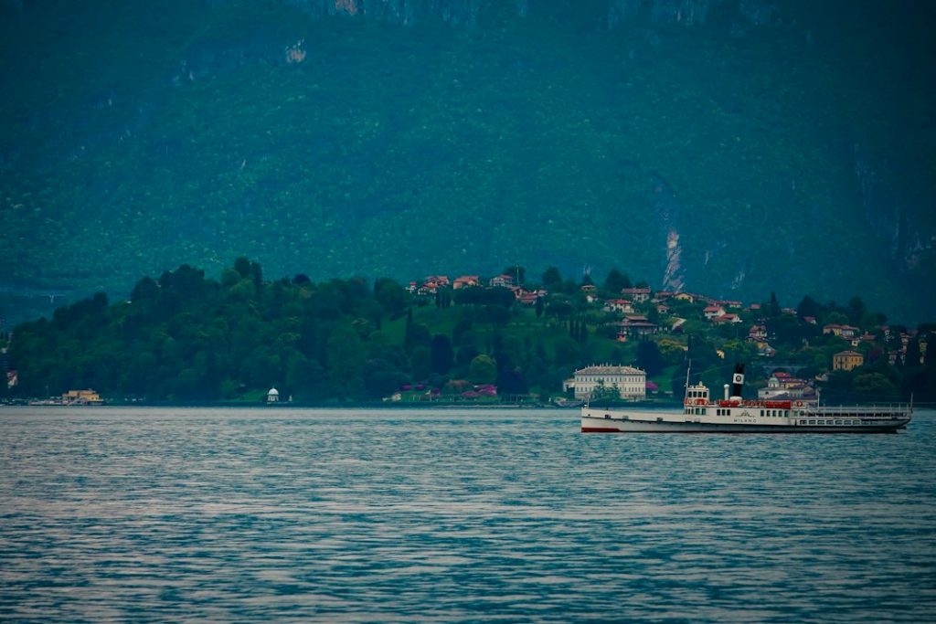 A vintage steamboat sails on a calm lake near shore