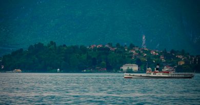 A vintage steamboat sails on a calm lake near shore
