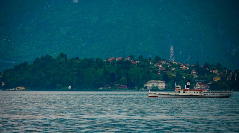 A vintage steamboat sails on a calm lake near shore